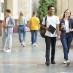 Gut gelaunte Studierende laufen auf dem Campus